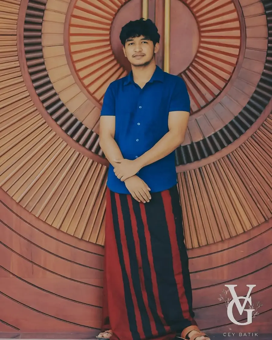 Man wearing a red and black striped sarong